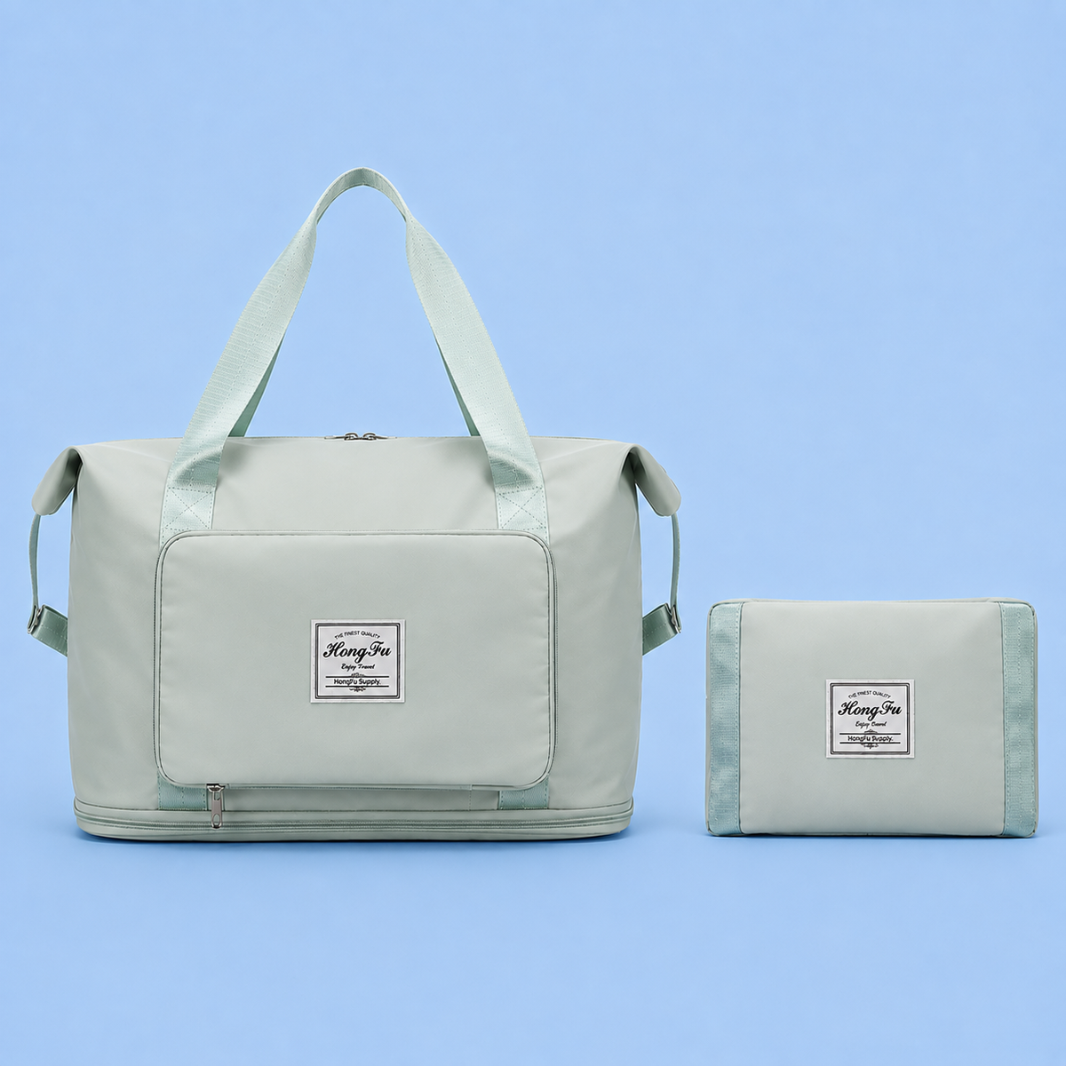 A light sage green duffel bag with matching shoulder straps and a front patch logo, shown next to its folded matching pouch on a solid light blue background. The patch reads 'HongFei'.